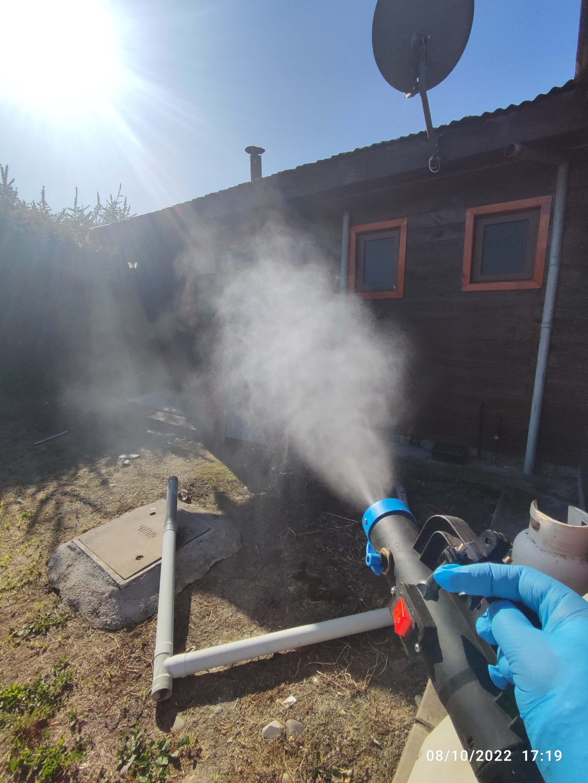 Técnico utilizando equipo de nebulización ULV para aplicar insecticida en entretecho contra arañas de rincón.